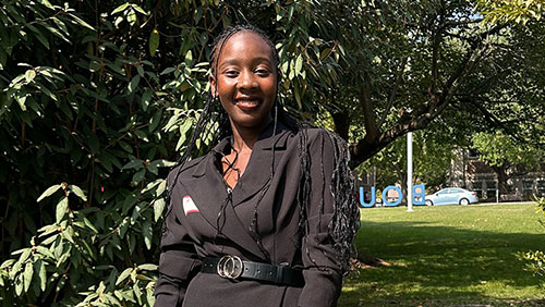 College student Ednah Asiema poses smiling outdoors on the campus of Muhlenberg College.