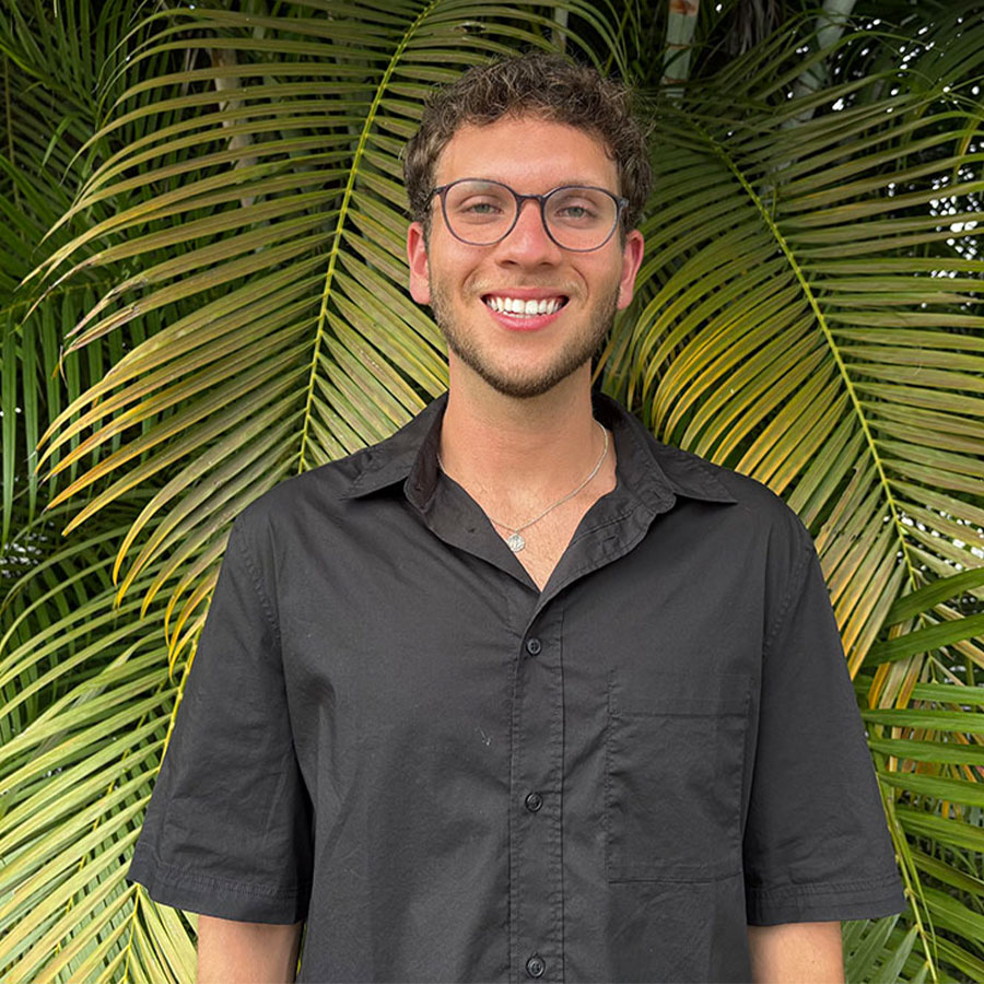 College student Adrián Padrón-Curet appears smiling outdoors in a tropical location.