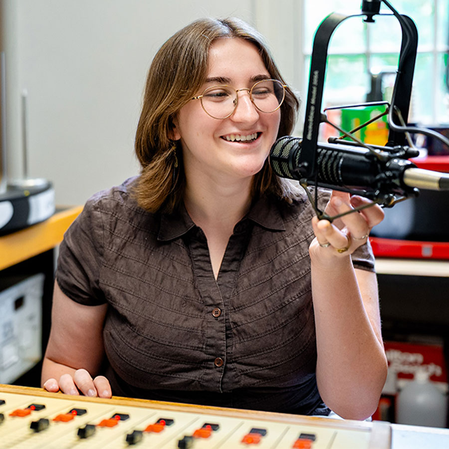 College student Amy Swartz speaks into a microphone at the WMUH radio station.