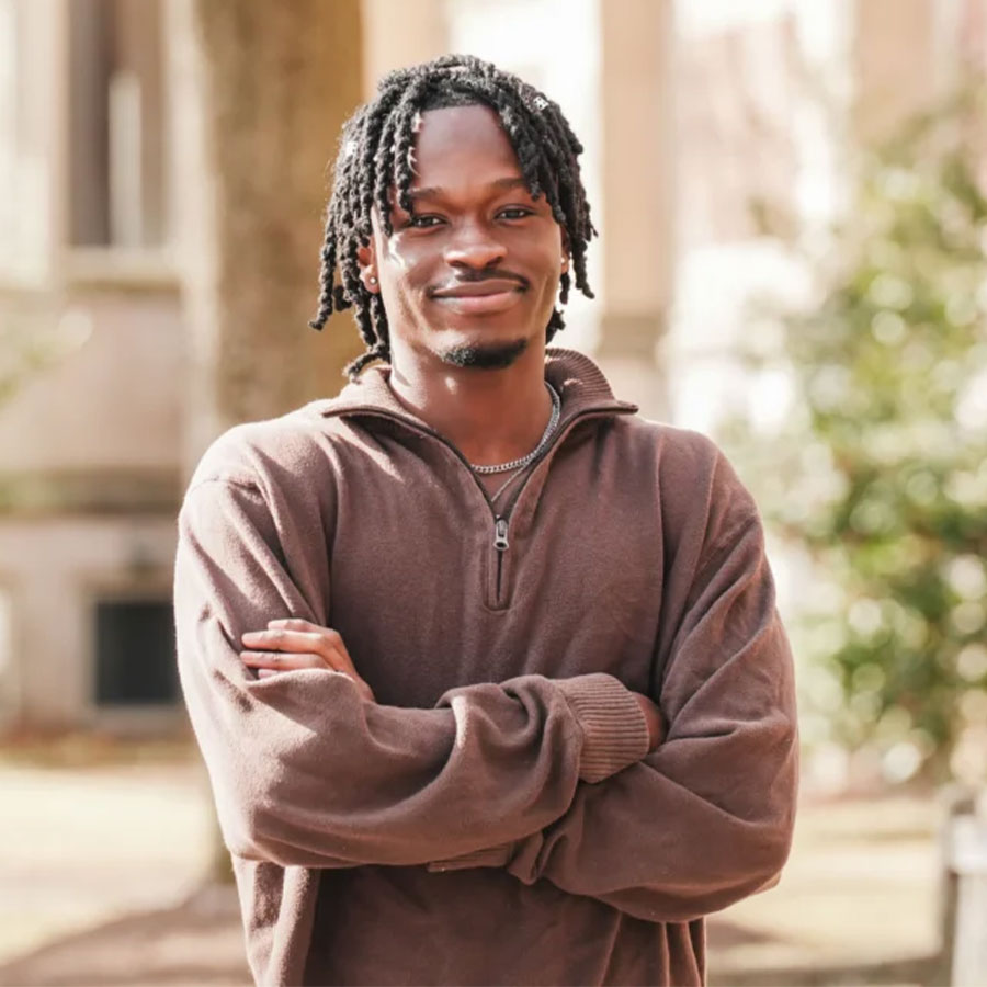 A grinning Ibrahim Sidibeh outdoors on the Muhlenberg College campus.