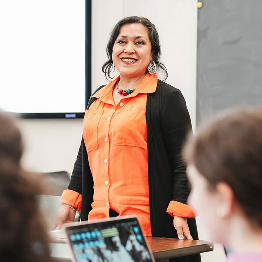 Leticia Robles-Moreno smiles while standing up in front of her classroom.
