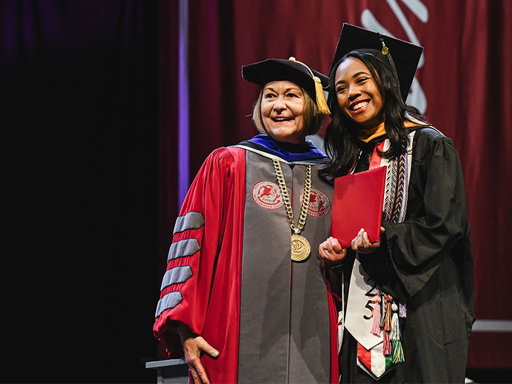 A new Muhlenberg graduate stands beside college President Kathleen Harring during a commencement ceremony.