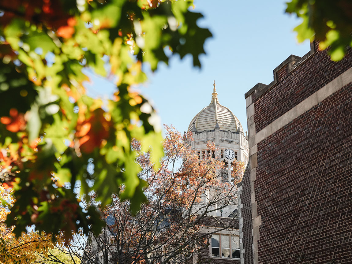 A view of the Haas bell tower through fall foliage