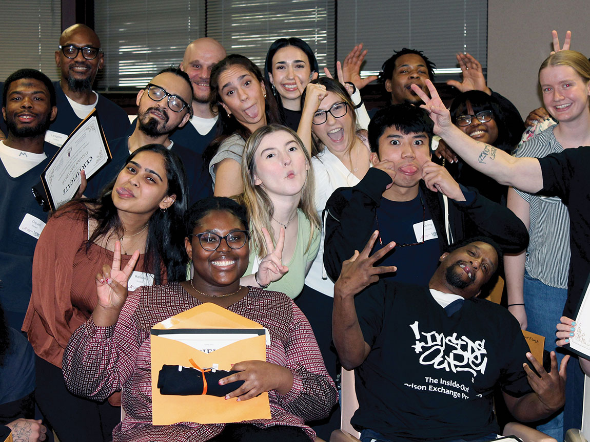 A group of college students and incarcerated students make silly faces for a photo
