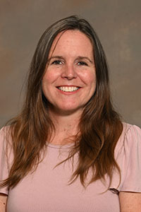 A headshot of a college professor with long hair